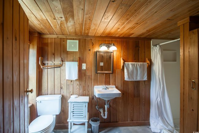 Full bathroom featuring wood ceiling, wooden walls, and a shower stall | Image 10