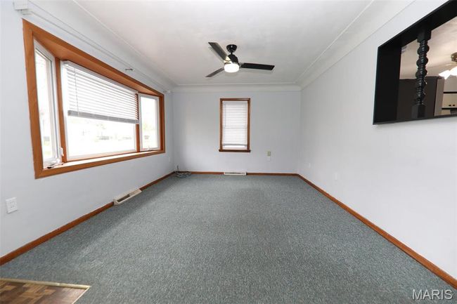 Carpeted spare room with baseboards, ceiling fan, visible vents, and crown molding | Image 8