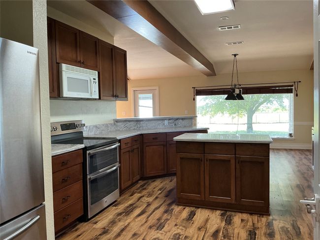 Kitchen with dark wood-type flooring, visible vents, pendant lighting, and stainless steel appliances | Image 7
