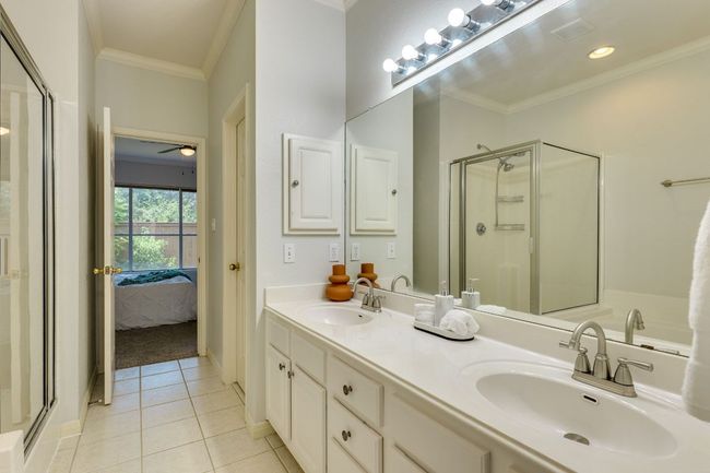 Bathroom with tile patterned flooring, a shower stall, crown molding, ensuite bath, and double vanity | Image 24