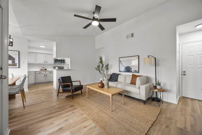 Living area featuring a ceiling fan and light wood-style floors | Image 14