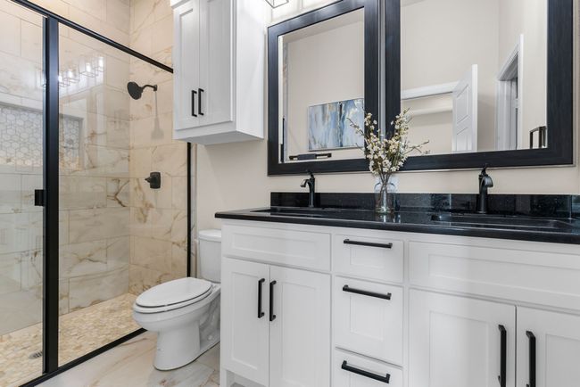 Primary bathroom featuring a stall shower, toilet, and a sink | Image 18