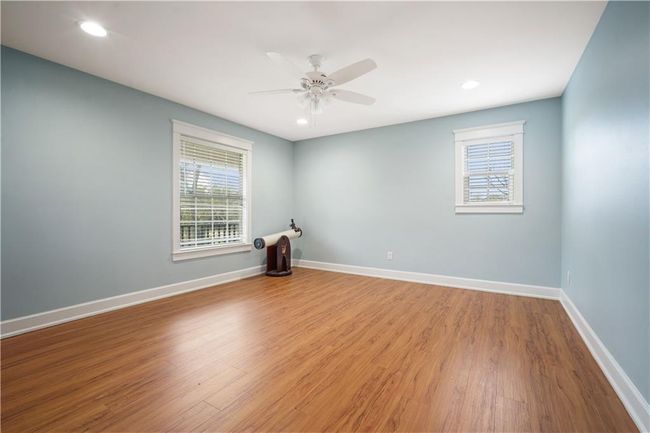 Empty room with baseboards, wood finished floors, ceiling fan, and recessed lighting | Image 22