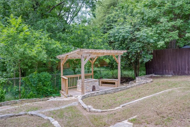 View of yard featuring a pergola, a wooden deck, and a fenced backyard | Image 32