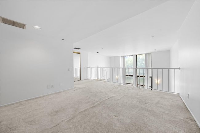 Unfurnished bedroom featuring carpet floors, baseboards, and a wall of windows | Image 16