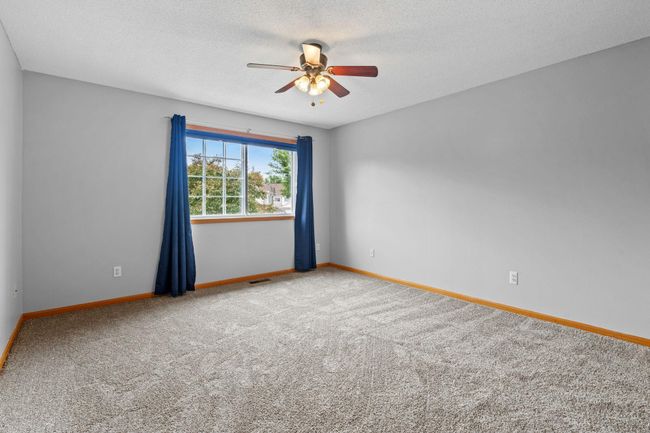 Generously sized primary bedroom with ceiling fan, large window, and ample natural light. | Image 20