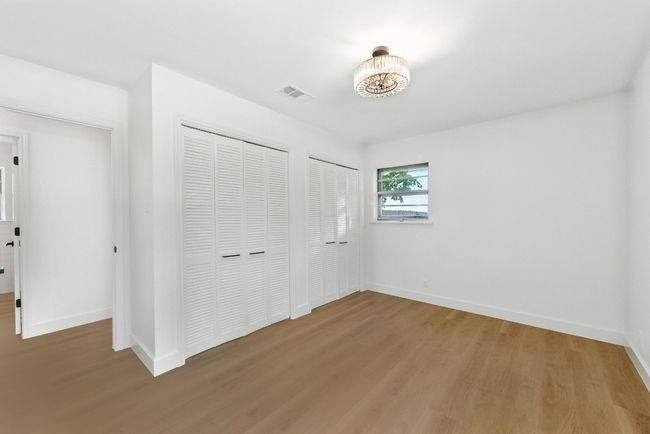Unfurnished bedroom featuring light wood-type flooring and two closets | Image 18