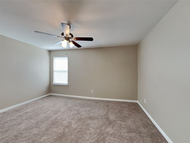 Empty room with ceiling fan and carpet | Image 12