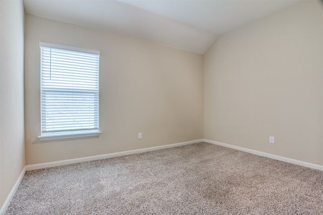 Carpeted spare room featuring lofted ceiling and baseboards | Image 10