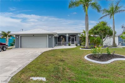 Single story home featuring a garage and a front lawn | Image 1