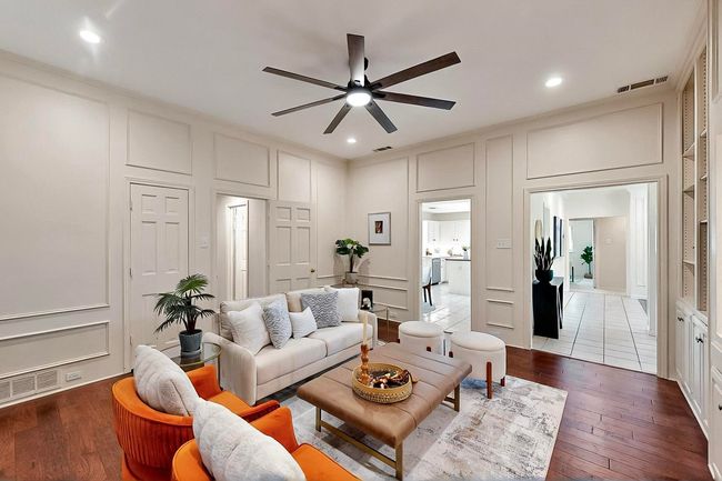 Living room with a decorative wall, a ceiling fan, wood-type flooring, recessed lighting, and ornamental molding | Image 5