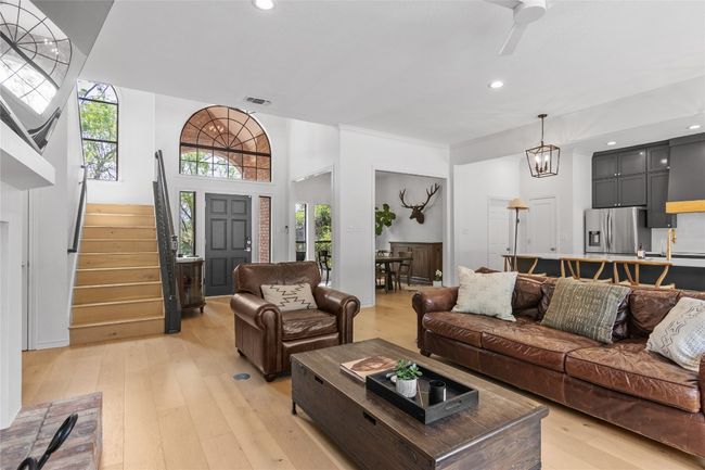 Living room with light wood-style floors, stairway, a healthy amount of sunlight, and visible vents | Image 11