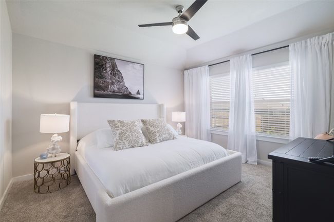 Large Primary Bedroom featuring light carpet and ceiling fan, and custom windows. | Image 16