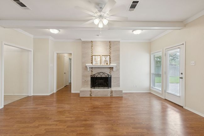 Spacious open living area with engineered hardwood flooring and high quality gas fireplace logs | Image 8