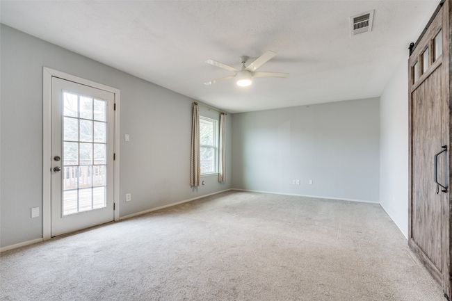 Carpeted empty room with ceiling fan and a barn door | Image 16