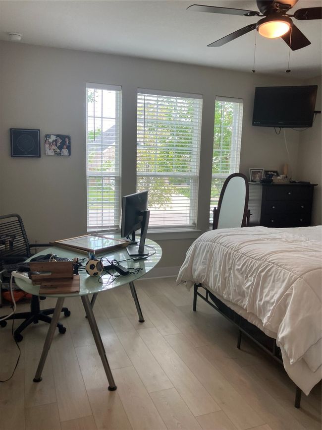 Bedroom featuring a desk, light wood-style flooring, baseboards, and ceiling fan | Image 16