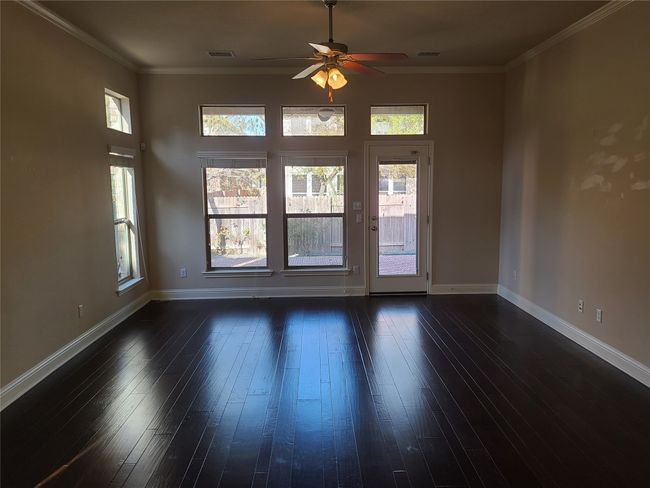 Spare room featuring a ceiling fan, dark wood-type flooring, and ornamental molding | Image 14