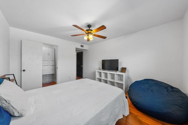 Bedroom with ceiling fan, wood-style flooring and spacious closet | Image 20