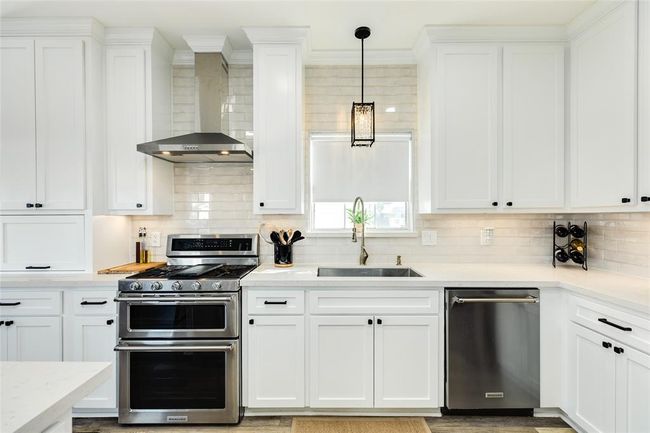 Upper cabinets are new, lower cabinets have been refaced. All cabinets freshly painted. Subway tile backsplash extends to the ceiling | Image 16