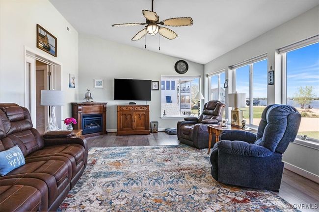 Living area featuring a fireplace, a ceiling fan, vaulted ceilings and river views for days!!!!! | Image 14