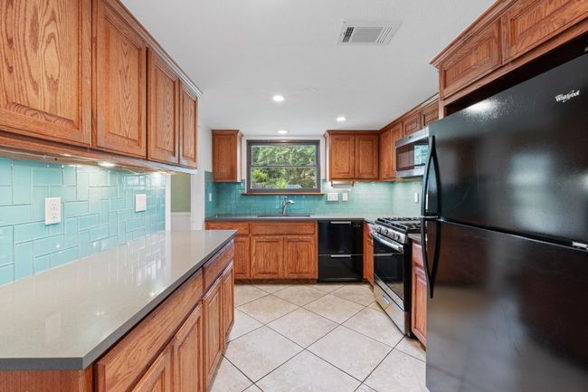 Stainless steel appliances include the gas range and the built-in microwave | Image 9