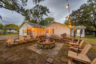 Back of property featuring an outdoor fire pit and a storage unit | Image 1