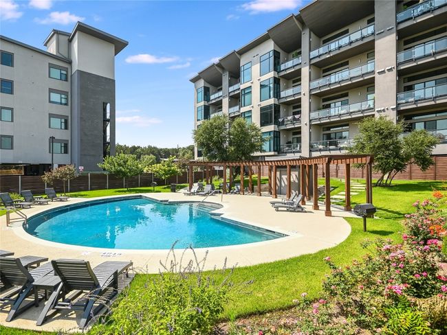 Well-manicured common area features fully-fenced community pool, bath, pergola, bbq grills, and lounge chairs. | Image 30