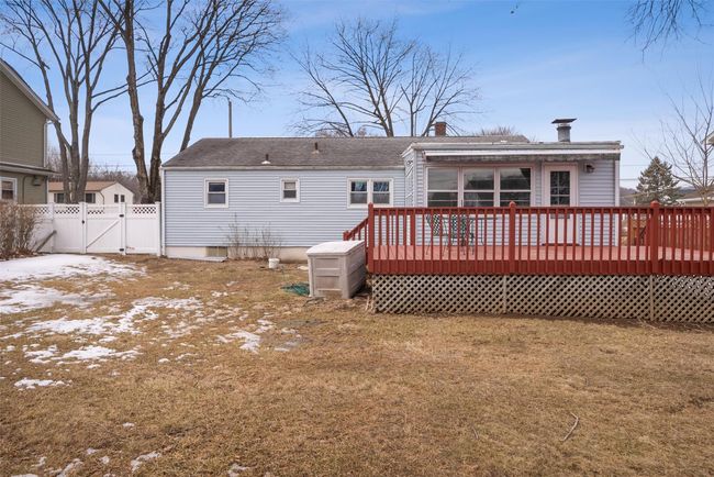 Rear view of house featuring a lawn, a wooden deck, a gate, and fence | Image 39