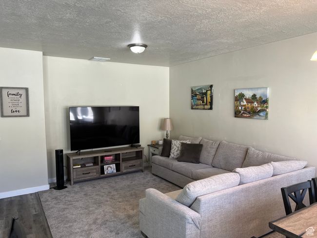 Living room featuring baseboards, visible vents, and a textured ceiling | Image 8