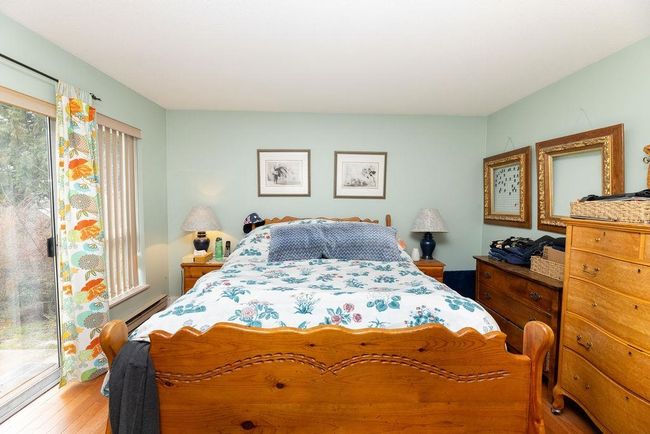Bedroom with baseboard heating and wood finished floors | Image 20
