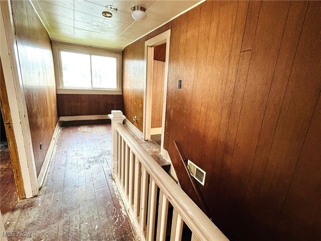 Corridor featuring an upstairs landing, hardwood / wood-style floors, and wooden walls | Image 14