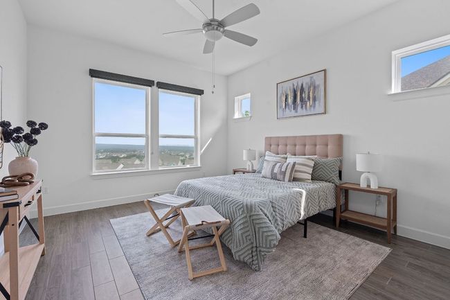 The secluded primary suite is nested away in the back corner of the home and also showcases incredible hill country vistas, perfect for relaxing in bed and watching storms roll in over the expansive horizon. | Image 6