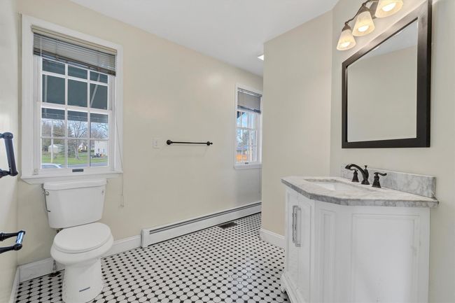 Bathroom featuring a baseboard radiator, baseboards, toilet, vanity, and tile patterned floors | Image 28