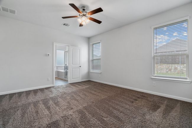 Carpeted spare room with baseboards, visible vents, and a ceiling fan | Image 10