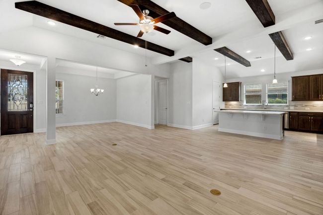 Unfurnished living room with recessed lighting, ceiling fan with notable chandelier, light wood-type flooring, and baseboards | Image 11