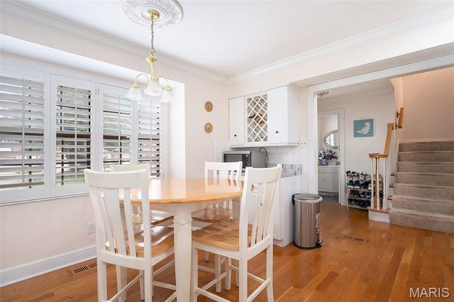 Dining space featuring light wood finished floors, stairs, and crown molding | Image 8