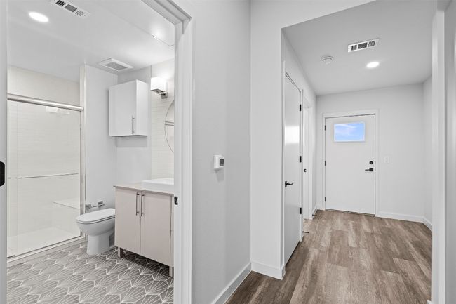 Full bathroom with vanity, toilet, a shower stall, and baseboards | Image 9