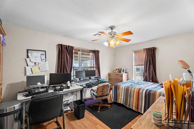 Bedroom with a ceiling fan, visible vents, a textured ceiling, and wood finished floors | Image 32