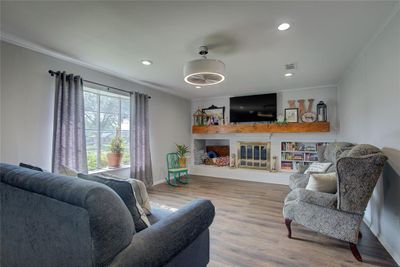 Living room featuring built in shelves, crown molding, and hardwood / wood-style floors | Image 3