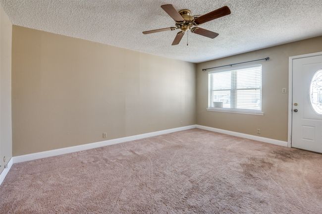 Foyer featuring ceiling fan, light carpet, and a textured ceiling | Image 5
