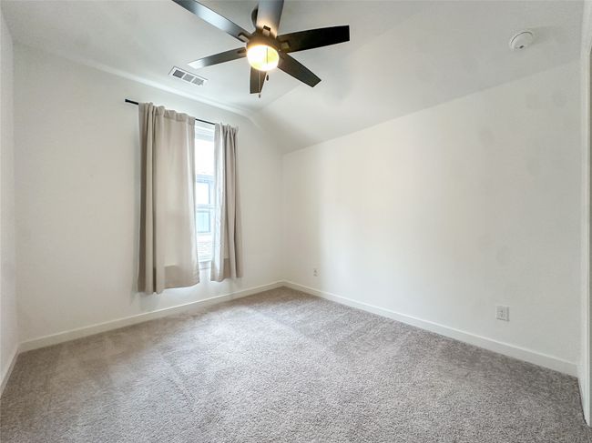Unfurnished room featuring a smoke detector, a ceiling fan, lofted ceiling, and carpet flooring | Image 26