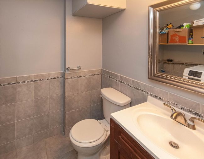 Half bath with vanity and tile walls in the lower level | Image 17