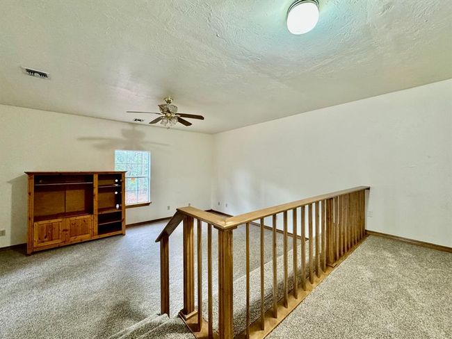 Stairs featuring carpet flooring, ceiling fan, and a textured ceiling | Image 11