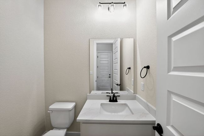 Half bath with a textured wall and vanity | Image 25