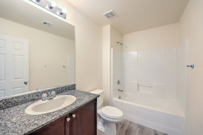 Bathroom with toilet, vanity, wood finished floors, and visible vents | Image 15