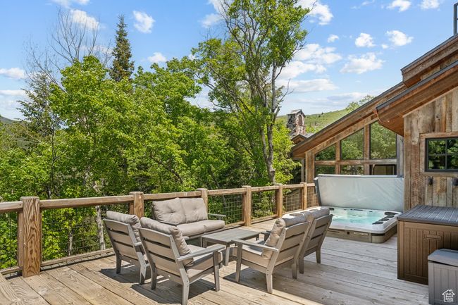 Deck featuring a covered hot tub and outdoor lounge area | Image 48