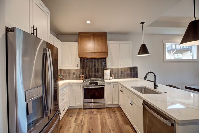 Kitchen featuring stainless steel appliances, a peninsula, white cabinetry, and recessed lighting | Image 4
