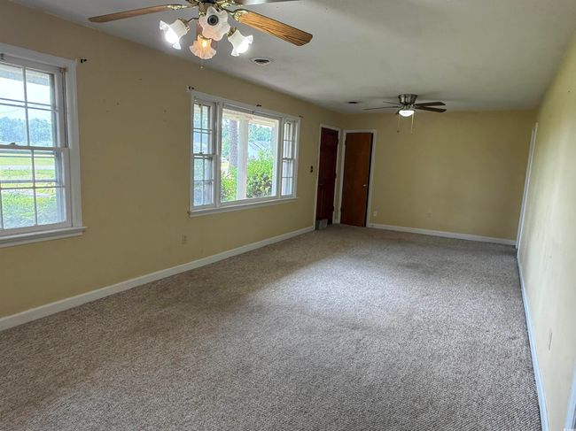 Unfurnished room featuring a ceiling fan, plenty of natural light, and carpet floors | Image 5
