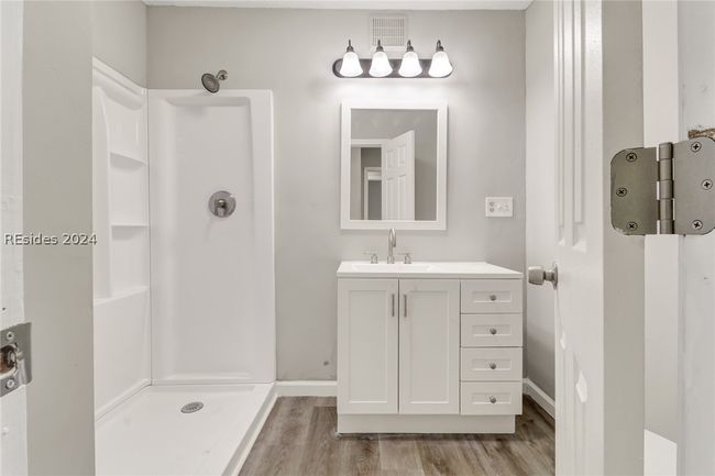 Bathroom featuring walk in shower, hardwood / wood-style floors, and vanity | Image 11