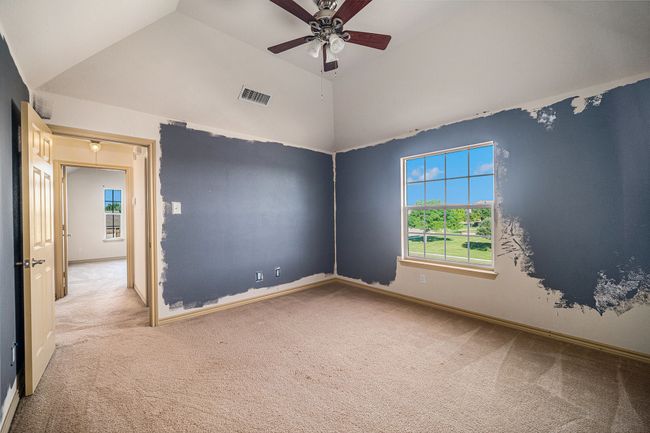 Carpeted spare room with vaulted ceiling, ceiling fan, and baseboards | Image 16